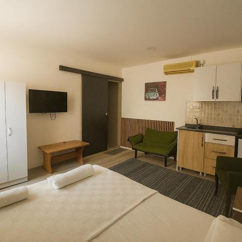 a room with a kitchen and a living room with a bed at Hillside Apart House in Side