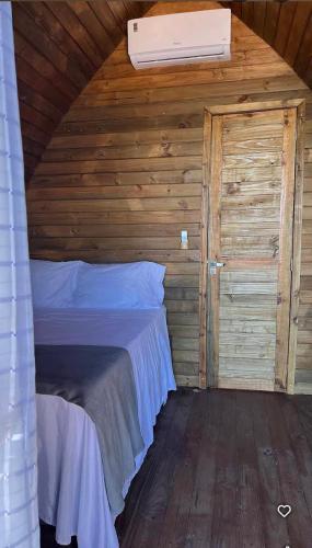 a bedroom with a bed in a wooden cabin at Peixe na Patioba in Porto Seguro