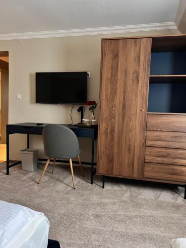 a bedroom with a desk and a television and a cabinet at Hotel Cocó in Timişoara