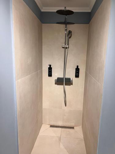 a shower with a shower head in a bathroom at Hotel Cocó in Timişoara