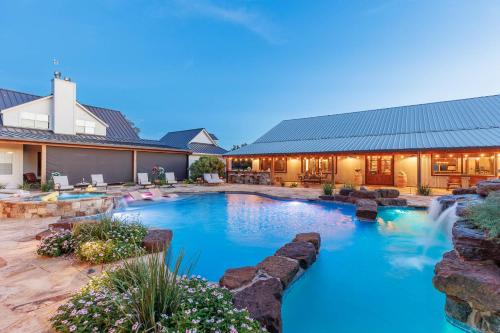 a swimming pool with a waterfall in a yard at Bent Oak Highland Ranch and Concierge Services in Burnet