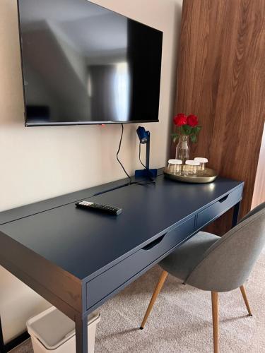a black desk with a television on a wall at Hotel Cocó in Timişoara