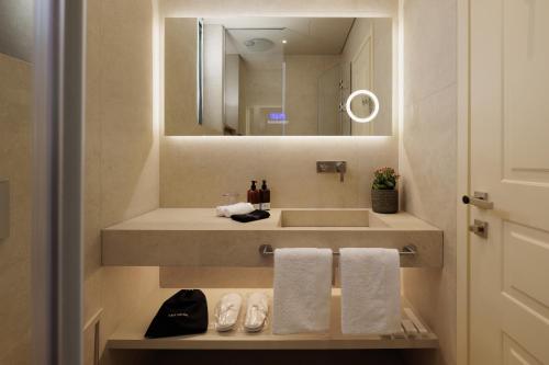 un bagno con lavandino e specchio di Albergo Botti a Città di Corfù