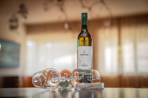a bottle of wine sitting on a table with glasses at Königswieser Hof in Königswiesen