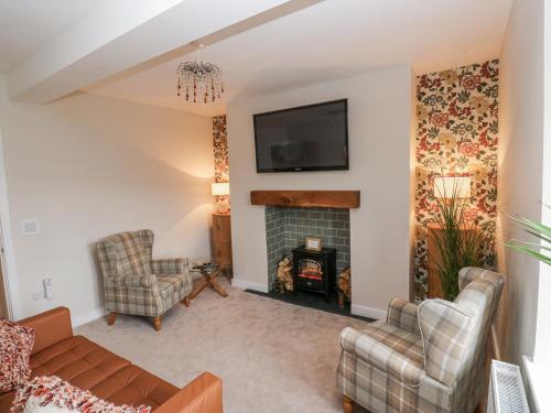 a living room with a couch and a fireplace at Millside View in Keighley