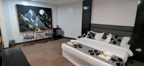 a bedroom with two beds and a table and a painting at Palette in Angeles Pampanga near Clark International Airport Formerly Boss Hotel in Angeles