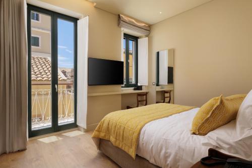 a bedroom with a bed and a balcony with a television at Albergo Botti in Corfu Town
