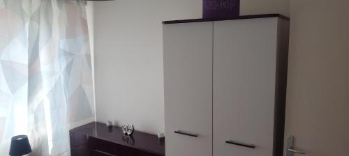 a white cabinet in a room with a window at La Meinau in Strasbourg