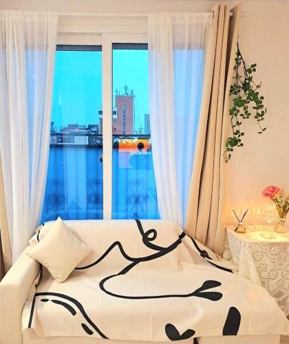 a bedroom with a bed and a large window at Gongrim Stay in Seoul