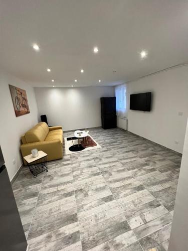 a living room with a couch and a flat screen tv at Grand studio tout équipé in Faverolles-sur-Cher