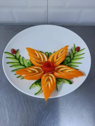 a white plate with a flower on it at The Ontime Hotel, Bangalore in Bengaluru