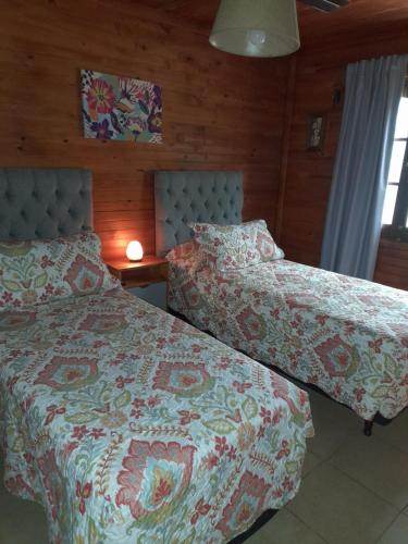 two beds sitting next to each other in a bedroom at Edna Cabañas in Tinogasta