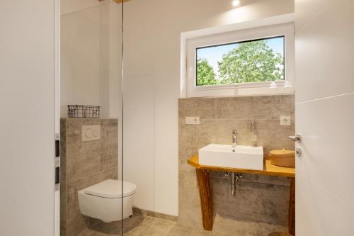 a bathroom with a sink and a toilet and a window at Forest Retreat- Serene 160m2 with Forest Views in Wermelskirchen