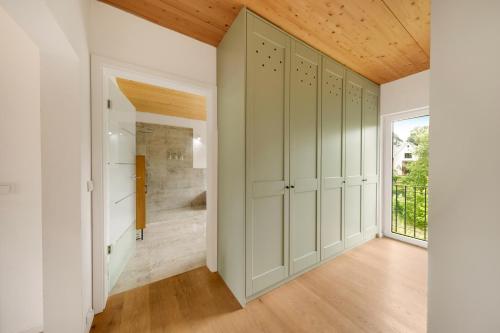 a walk in closet with green cabinets and a window at Forest Retreat- Serene 160m2 with Forest Views in Wermelskirchen