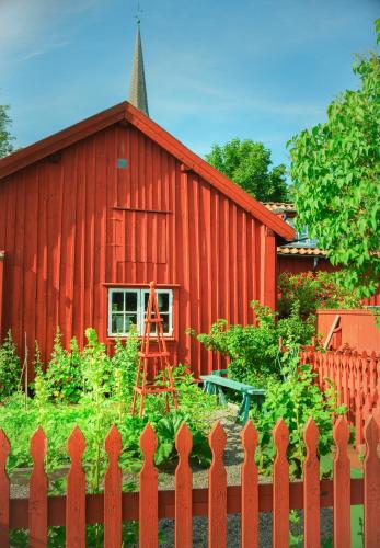 a red barn with a fence in front of it at Röda Magasinet in Mariefred