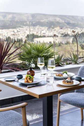 a table with plates of food and wine glasses at Amalia Hotel Athens in Athens