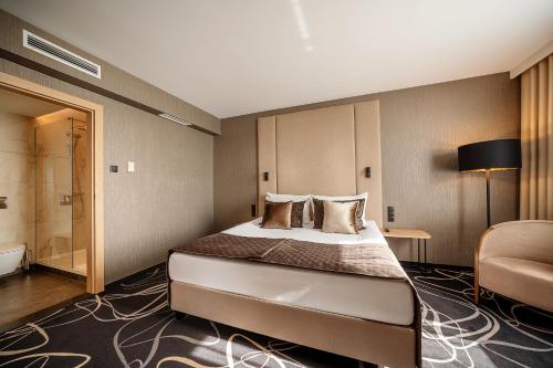 a hotel room with a bed and a chair at Airport Hotel Okęcie in Warsaw