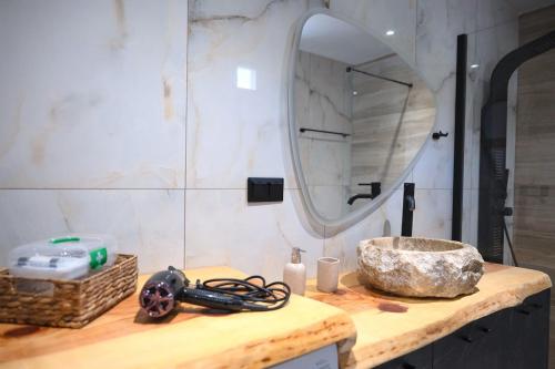 a bathroom with a sink and a mirror on a counter at Villa Optasia Scenic Eco Home w private pool in Krousón