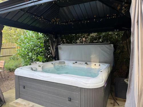 ein Whirlpool unter einem Baldachin in der Unterkunft Rogate Cottage Retreat in Petersfield