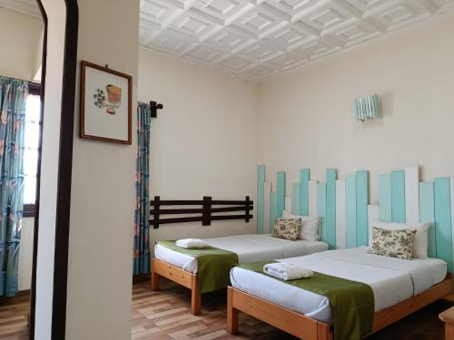a room with two beds and a mirror at Hotel Mahamanina in Fianarantsoa