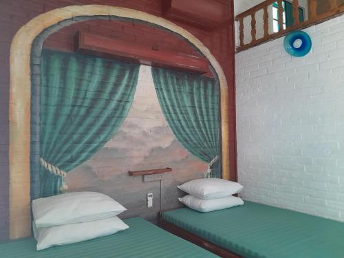 a room with a window with two pillows on a bed at Mina Café & Stay in Quan Lạn