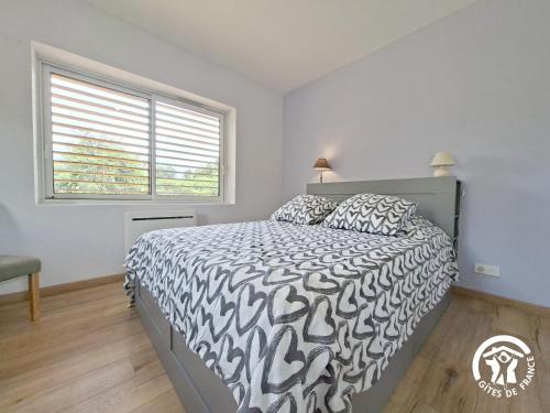 a bedroom with a bed with a black and white comforter at Cafumat in Lectoure