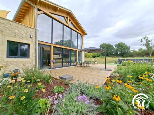a house with a wooden deck and a garden at Cafumat in Lectoure