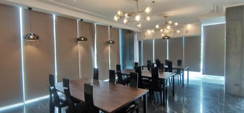 a dining room with wooden tables and black chairs at Sunday Hevea Hotel and Resort in Angeles