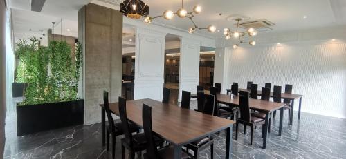 a dining room with wooden tables and black chairs at Sunday Hevea Hotel and Resort in Angeles