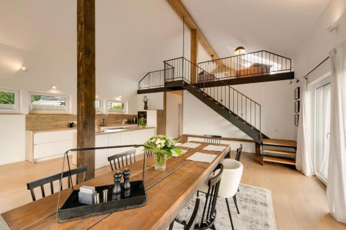 a dining room with a wooden table and a staircase at Forest Retreat- Serene 160m2 with Forest Views in Wermelskirchen