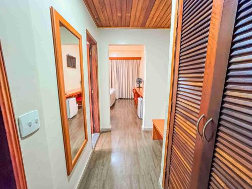 a hallway with a mirror and a room at Hotel Nacional Inn Campos do Jordão in Campos do Jordão