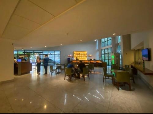 un vestíbulo con gente sentada en las mesas de un edificio en Excelente Flat Boa Viagem Andar Alto, en Recife