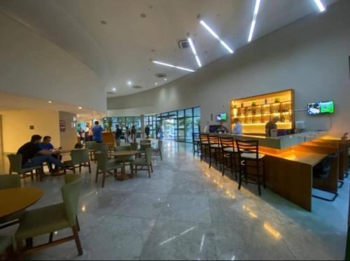 un restaurante con gente sentada en mesas y sillas en Excelente Flat Boa Viagem Andar Alto, en Recife