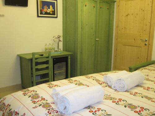 a bedroom with two beds with towels on them at R&B La Gerla Blu in Tolmezzo