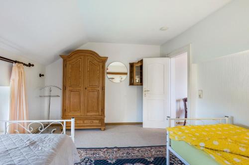 a bedroom with a bed and a wooden cabinet at Gästehaus Ziegler in Neuenkirchen