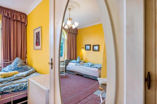a bedroom with two beds and a mirror at Gästehaus Ziegler in Neuenkirchen
