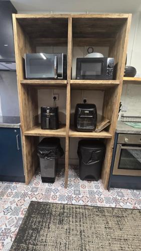 a book shelf with two microwaves and a microwave at Cysgu Dda - Sleep Well in Pembroke Dock
