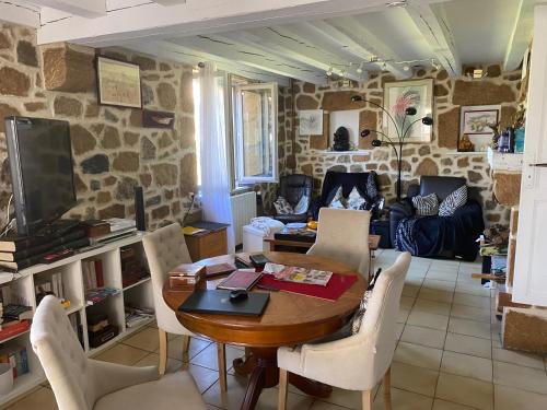 a living room with a table and chairs at maison fleurie in Saint-Germain