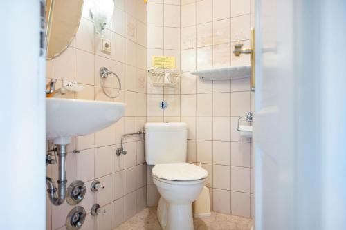 a bathroom with a toilet and a sink at Gästehaus Ziegler in Neuenkirchen