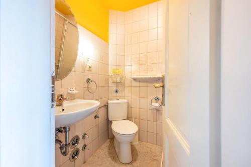 a bathroom with a toilet and a sink at Gästehaus Ziegler in Neuenkirchen