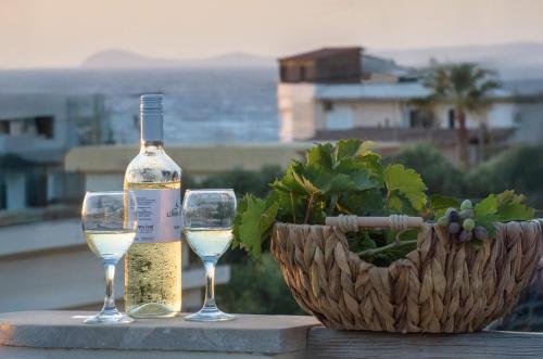 Una botella de vino y dos copas en una mesa en Villa Haris, en Kokkíni Khánion