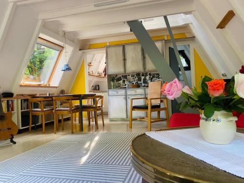a kitchen and dining room with a table and flowers at Ferienhaus am Waldrand in Billerbeck
