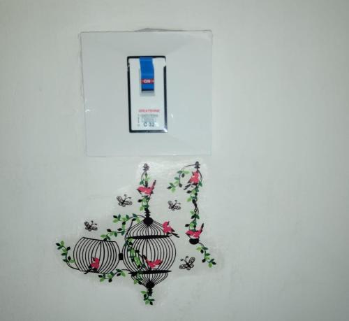 a bird cage with flowers on a white wall at Omax vrindavan in Chhatikara