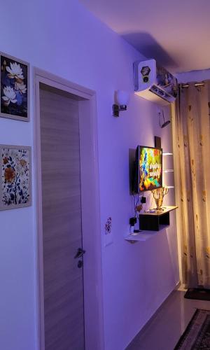 a room with a door and a tv on the wall at Omax vrindavan in Chhatikara