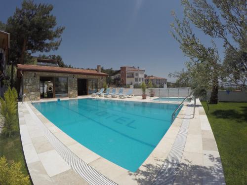 a large swimming pool with chairs in a yard at Pınar Vintage House in Pamukkale