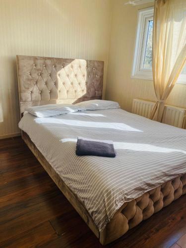 a large bed in a bedroom with a towel on it at Budget Rooms & Beds in London in London