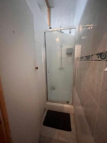 a shower with a glass door in a bathroom at Budget Rooms & Beds in London in London
