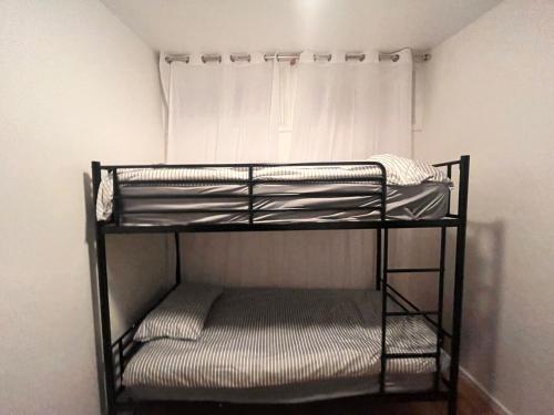 a black bunk bed in a room with a wall at Budget Rooms & Beds in London in London