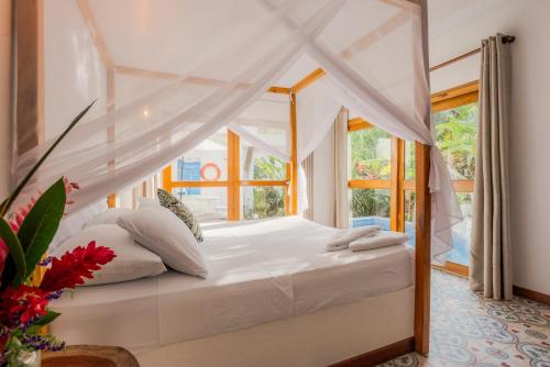a bedroom with a bed with a canopy at Casa del Pavo Real Boutique Hotel in Palomino