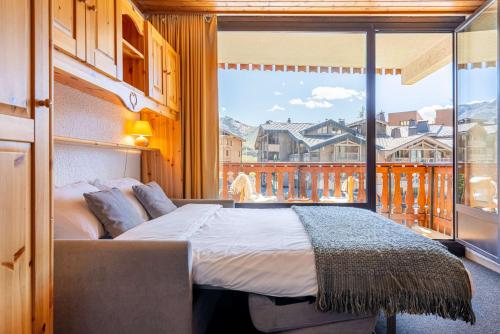 a bedroom with a bed and a large window at Cosy Apartment In Heart of Val Thorens, Ski In-Out with WiFi in Val Thorens